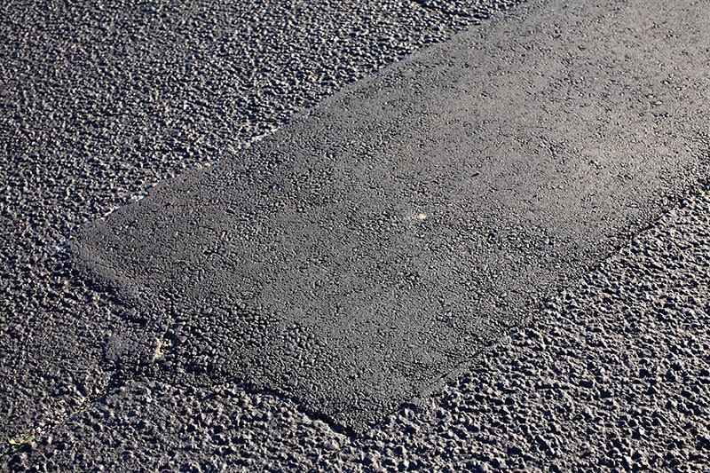 asphalt tarmac patch on concrete ground repair pavement road in parking lot
