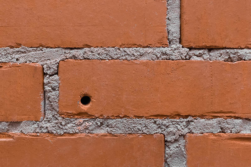 drilled hole circle in brown brick wall