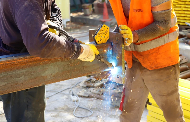 workers using a welding machine at a construction site