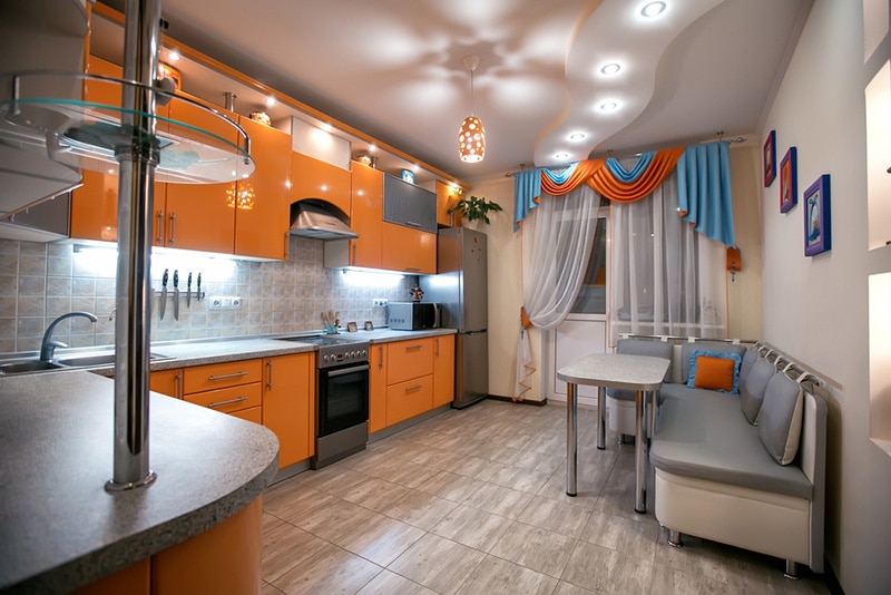 Comfortable apartment in the orange and blue tones. Kitchen with dining room