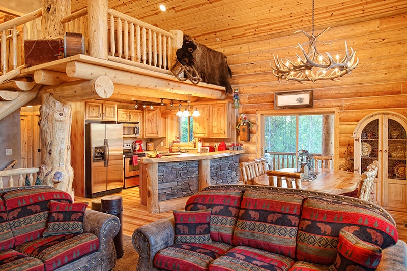 The interior of a modern log cabin with antler chandelier