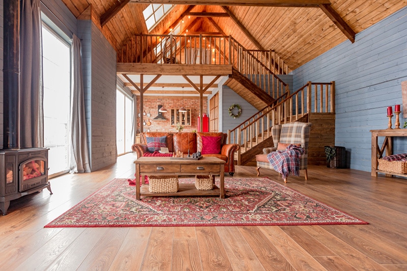 cozy interior of a country house in a wooden design. spacious living room with kitchen area with large windows
