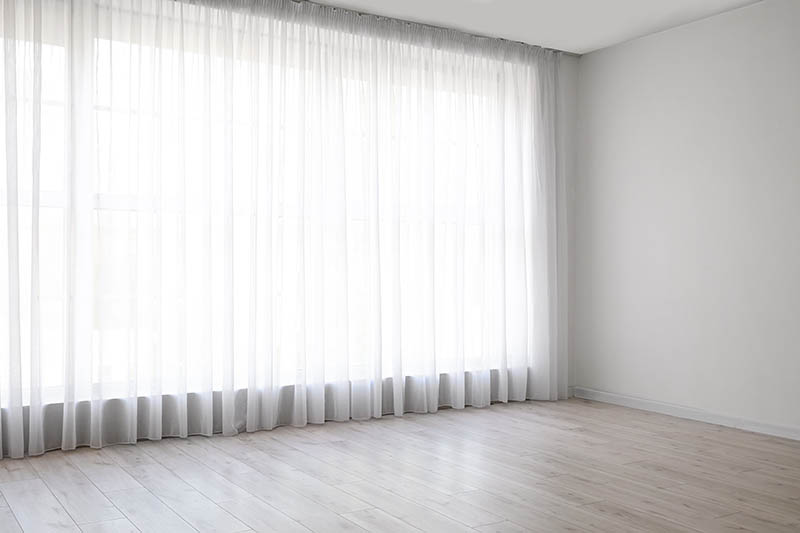 Light curtains on big window in empty room