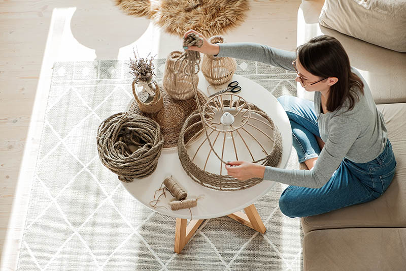Woman makes handmade diy lamp from jute rope at home