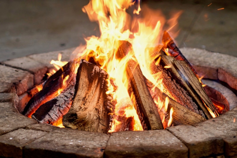wood logs burning in stone fire pit