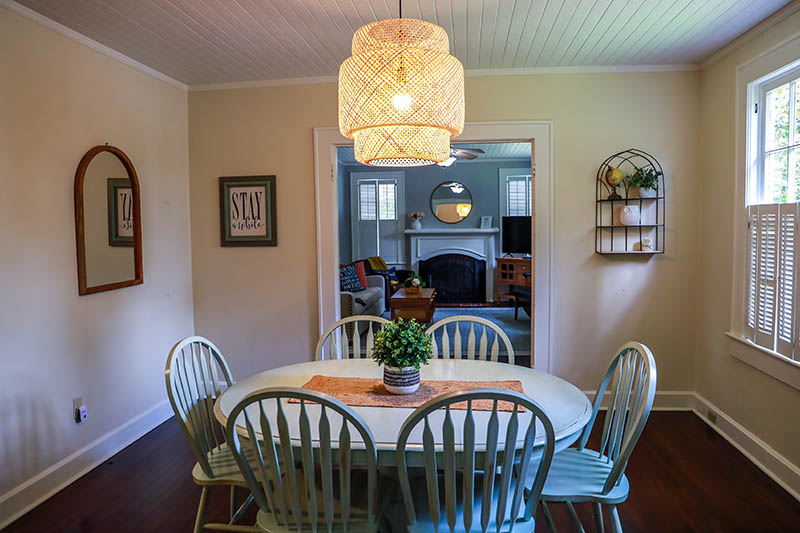 A small dining room with a statement rattan